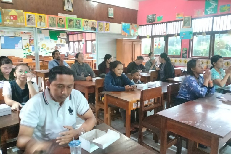 Orang tua siswa dan guru mendengarkan materi yang disampaikan
